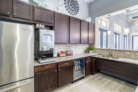A modern kitchen with dark wood cabinets and a stainless steel refrigerator.