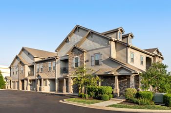 A large, modern house with a stone facade and multiple windows.