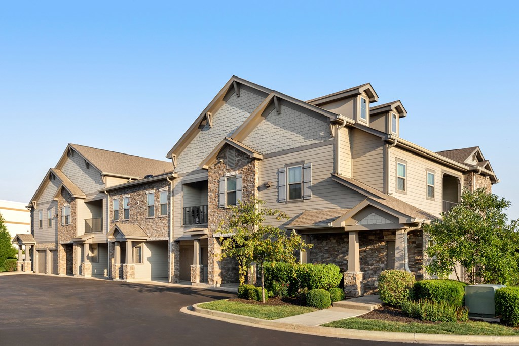 A large, modern house with a stone facade and multiple windows.