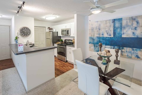 A modern kitchen with a bar area and a dining table set up.