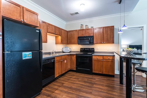 A kitchen with wooden cabinets and black appliances.