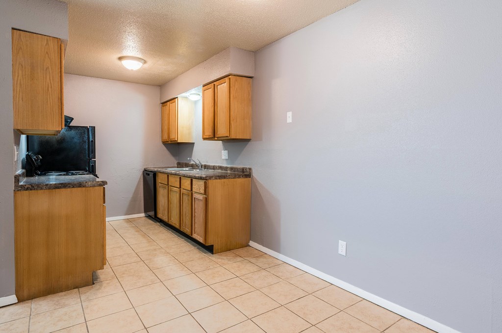 A kitchen with wooden cabinets and a black fridge.at 3TEN, Springfield, 62704