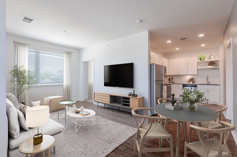 A modern living room with a grey table and white chairs.