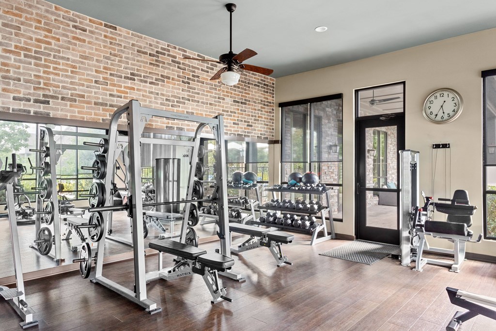 A gym with a brick wall and a variety of equipment.