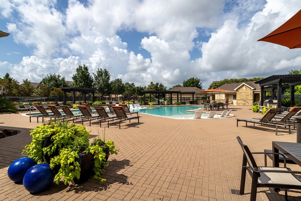 Pool area with a table and chairs at Grand Villas at Cinco Ranch, Texas, 77494