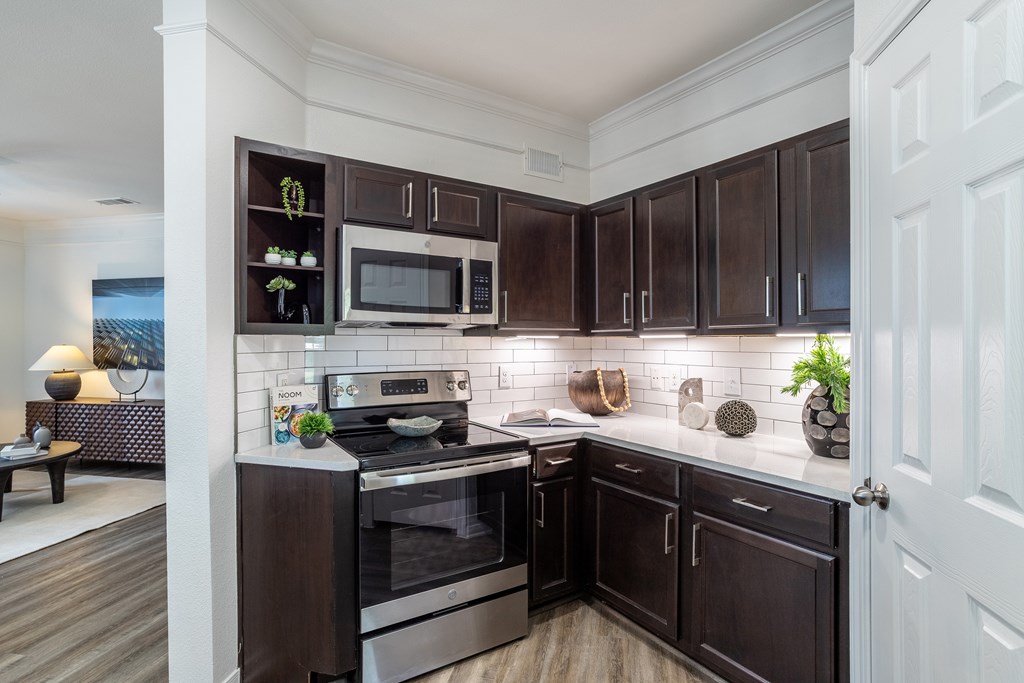 Kitchen with dark brown cabinets at Grand Villas at Cinco Ranch, Katy, TX, 77494