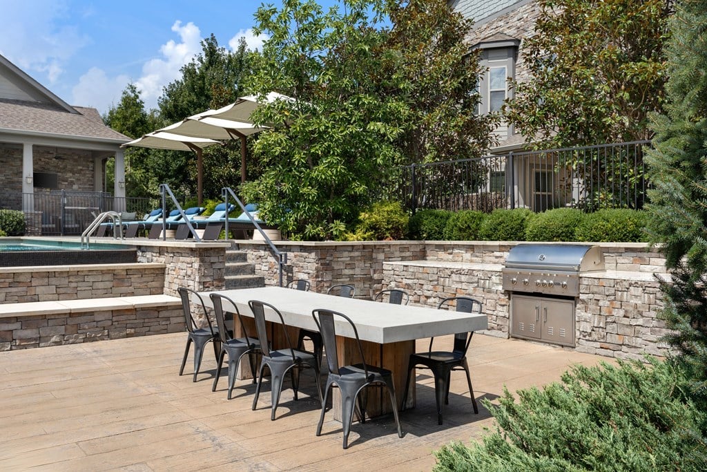 A table with chairs is set up on a wooden deck.