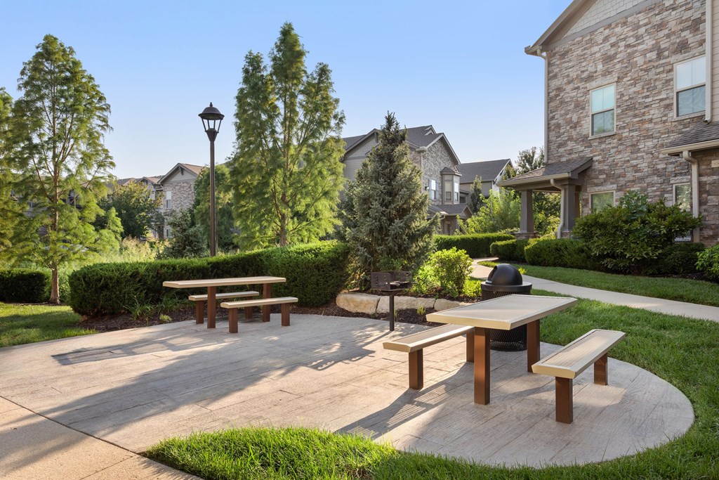 A park with benches and a picnic table in the foreground.