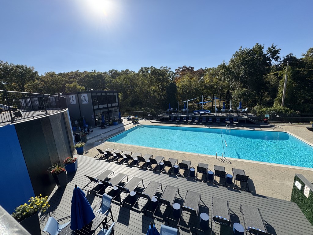 an aerial view of a swimming pool and deck with chairs at The Boulevard, Roeland Park, KS