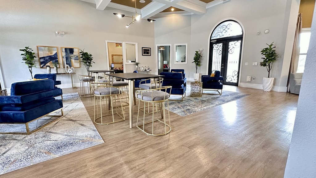 a living room with blue couches and chairs and a table with chairs