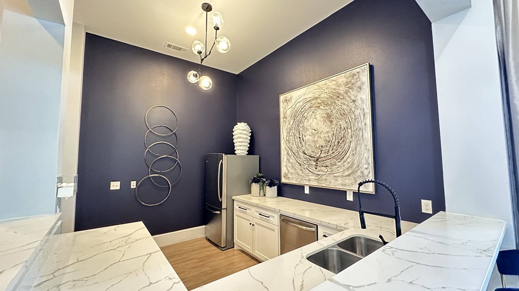 a bathroom with blue walls and a marble counter top and a sink