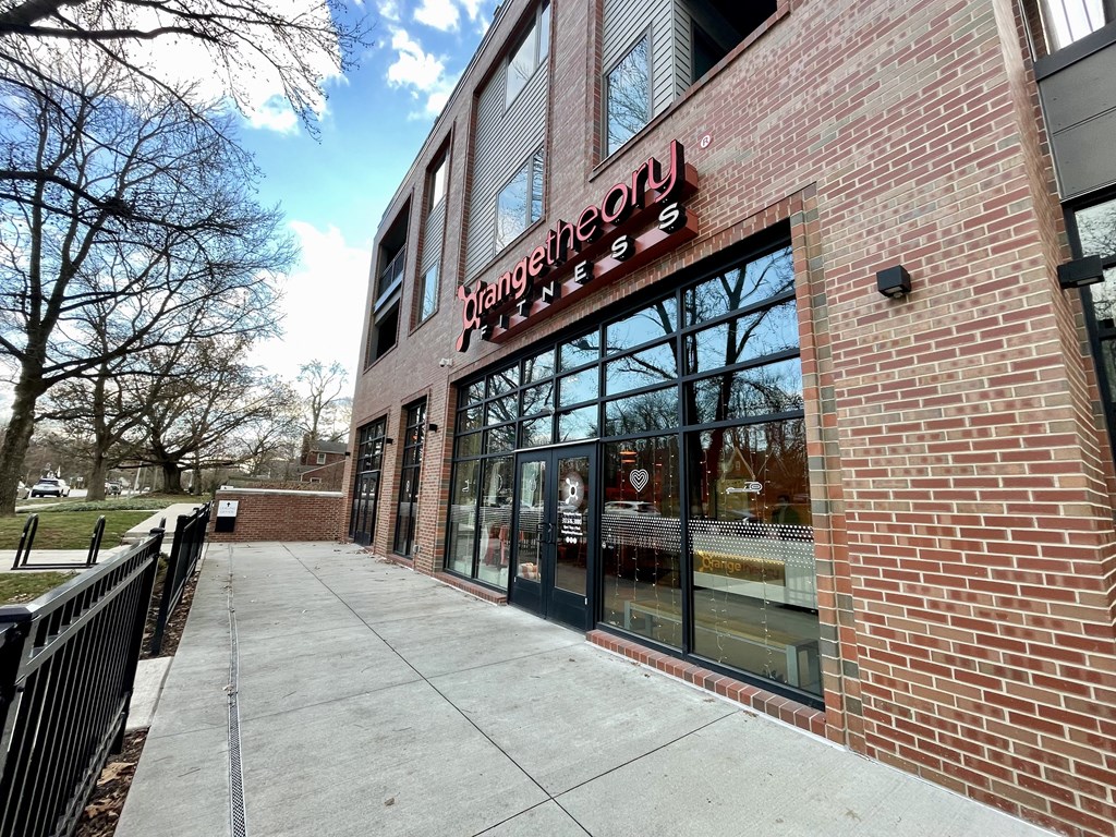 a brick building with a sign in the window and a sidewalk