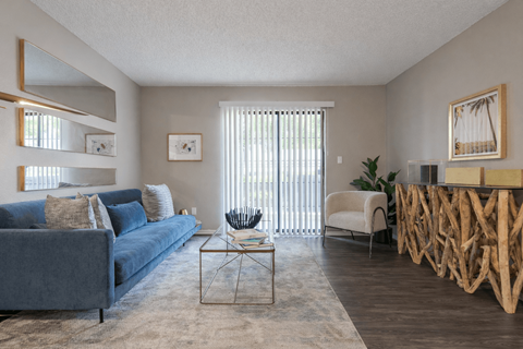 A living room with a blue couch and a wooden coffee table.