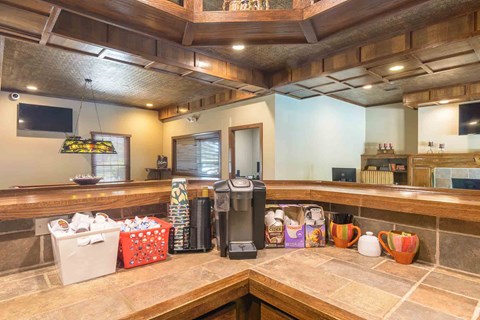 Community coffee bar with wooden cabinetry at London House Apartments, Lenexa, KS