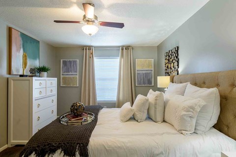A bedroom with a large bed and a ceiling fan.