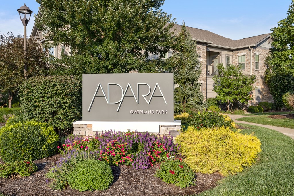 A sign that says Adara Overland Park in front of a building.