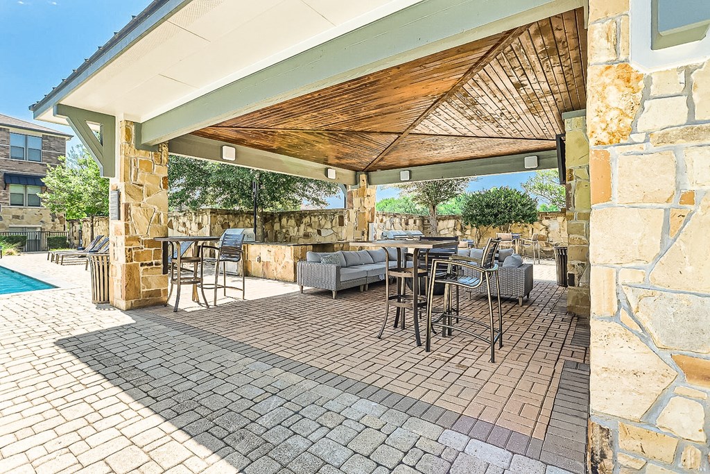 a covered patio with tables and chairs and a pool at Discovery at Craig Ranch, McKinney