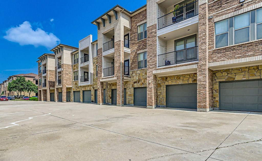 an empty parking lot in front of an apartment building at Discovery at Craig Ranch, McKinney