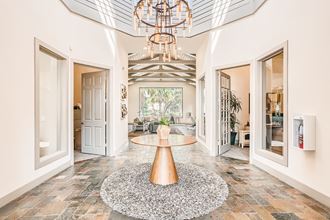 a foyer with a round table and a chandelier