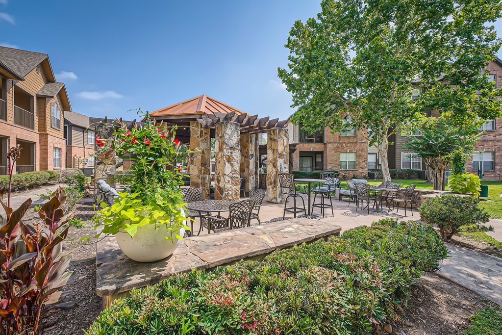 our apartments offer a courtyard with tables and chairs and plants at River Pointe, Texas