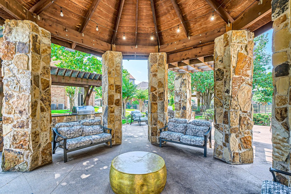 a covered patio with couches and a table at River Pointe, Texas