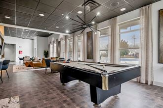 a game room with a pool table and windows at CityView, North Kansas City, Missouri