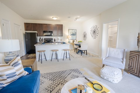 A living room with a blue couch and a white chair.