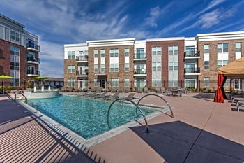 pool with apartment building in the back - Photo Gallery 4