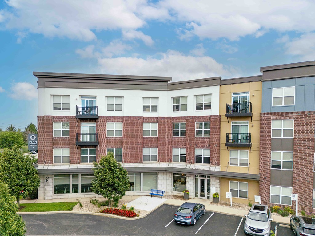 A multi-story apartment building with a parking lot in front.