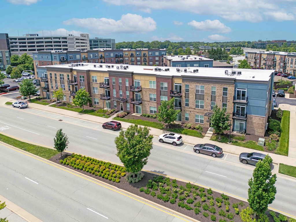 A street view of a residential area with cars parked on the side of the road.