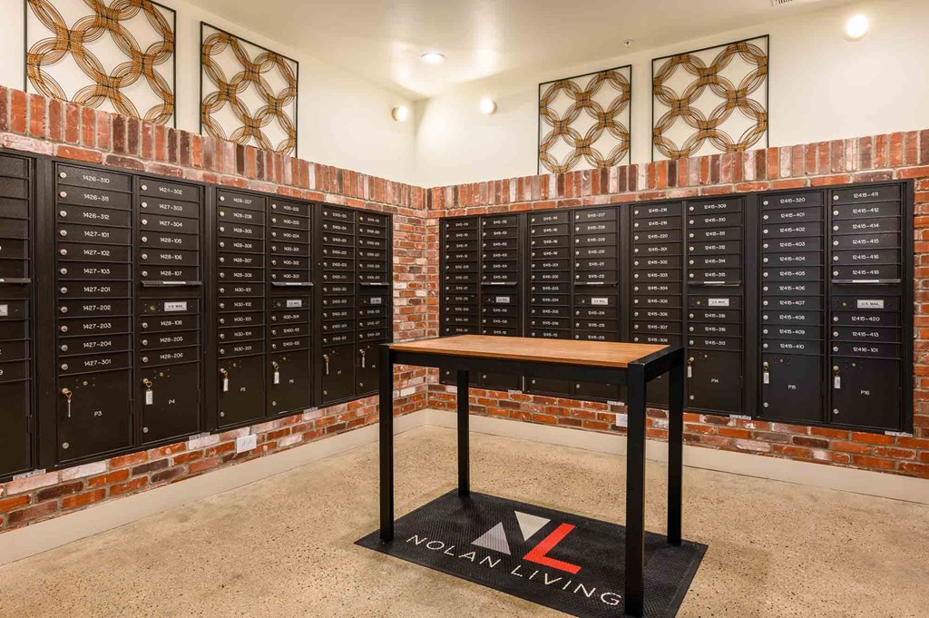 A room with a table in front of a wall of lockers.