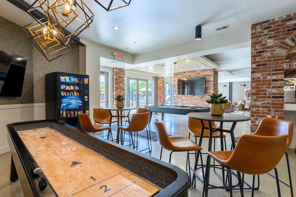 A room with a shiny table and chairs and a television.
