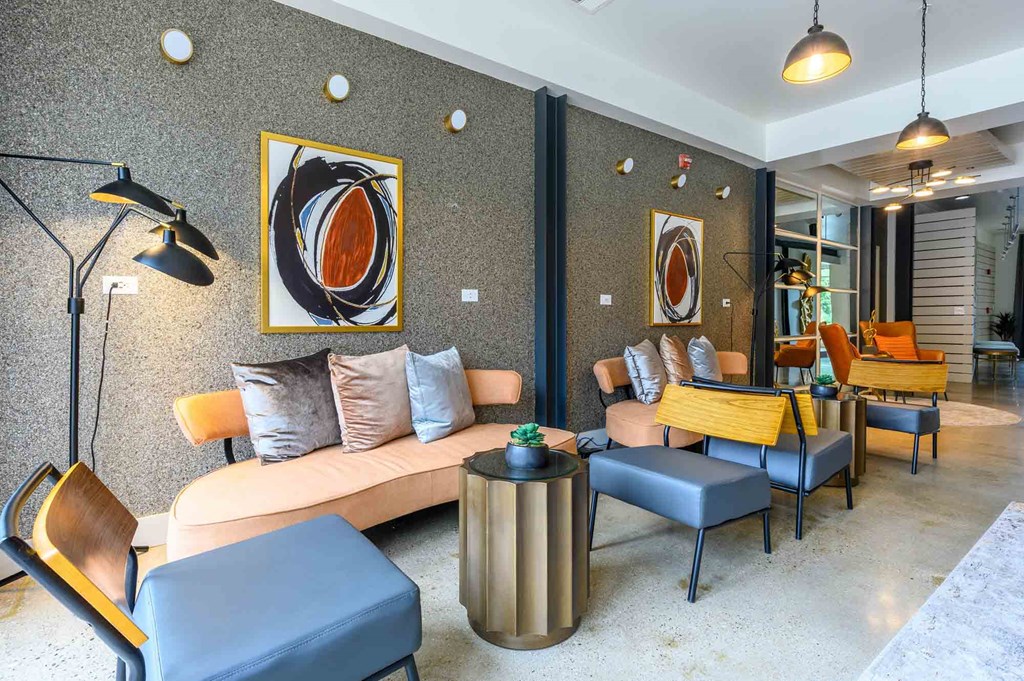 A modern living room with a grey sofa, a blue ottoman, and a yellow chair.