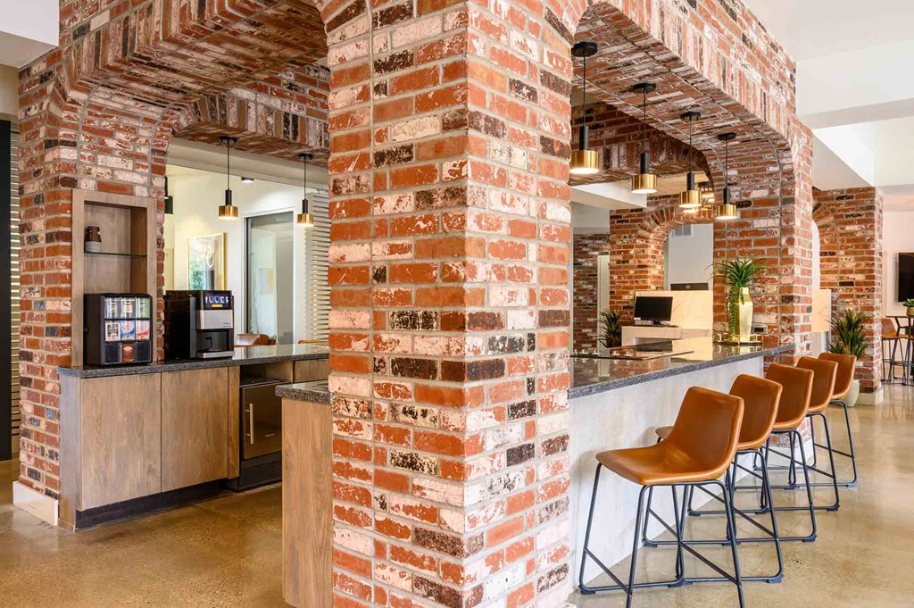 A row of chairs are lined up in front of a brick wall.