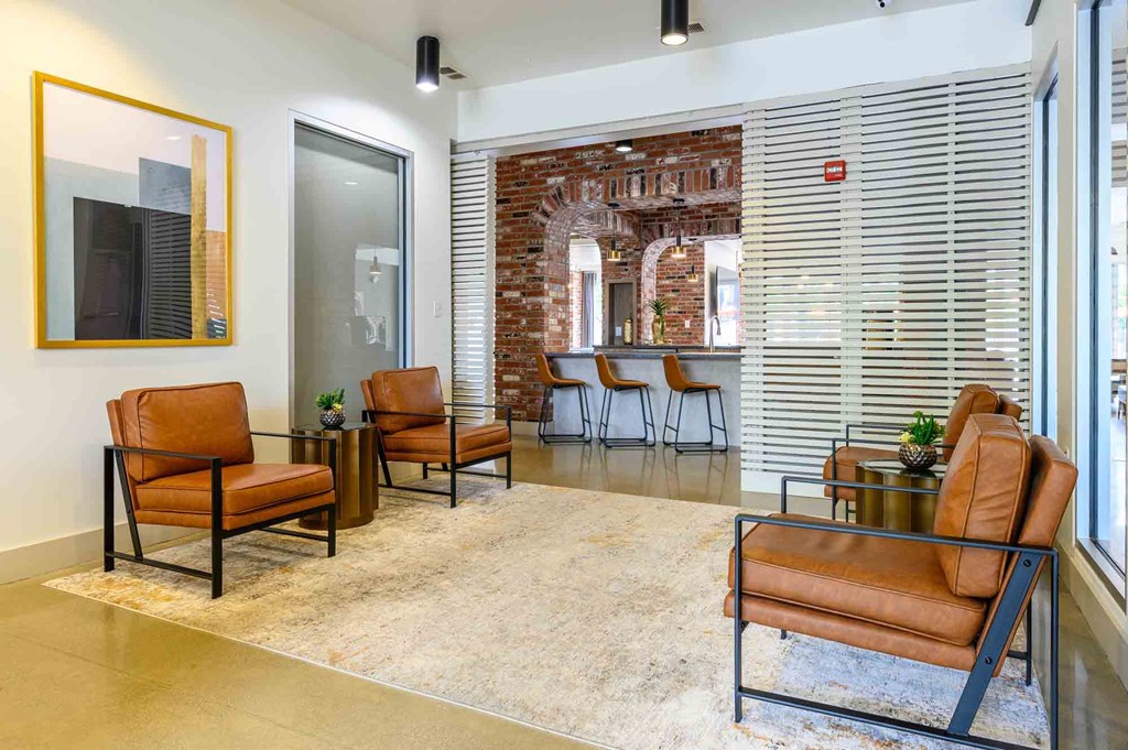 A room with a brick wall and a row of chairs.