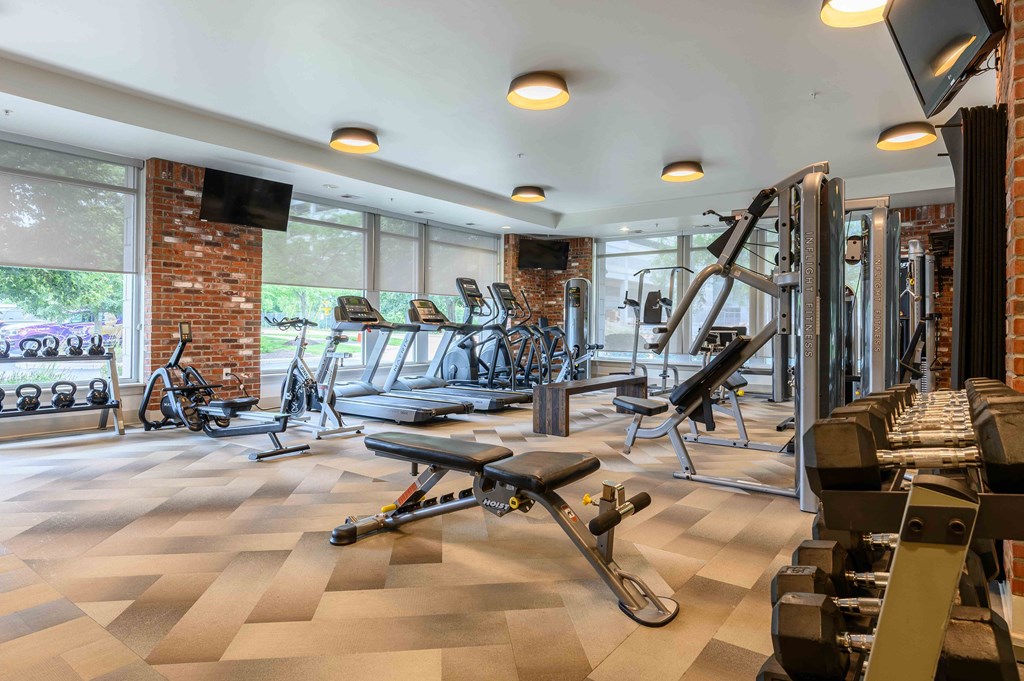 A gym with a variety of equipment including weights and cardio machines.