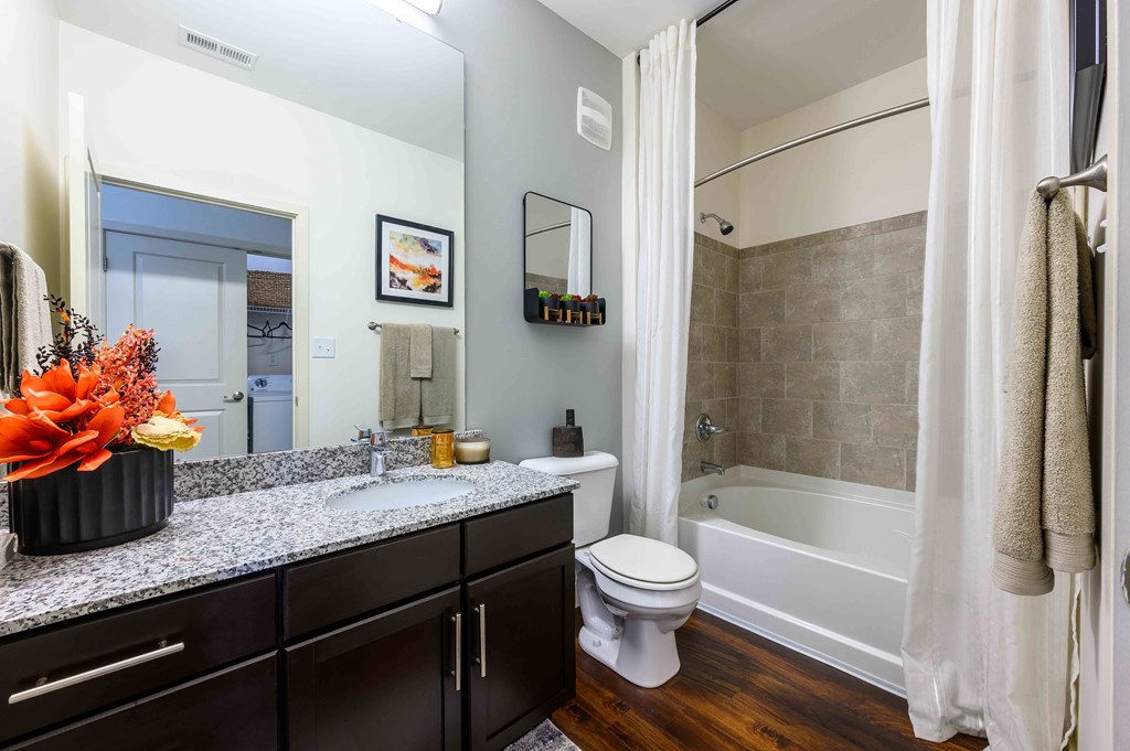 A bathroom with a white toilet, a sink, and a bathtub.
