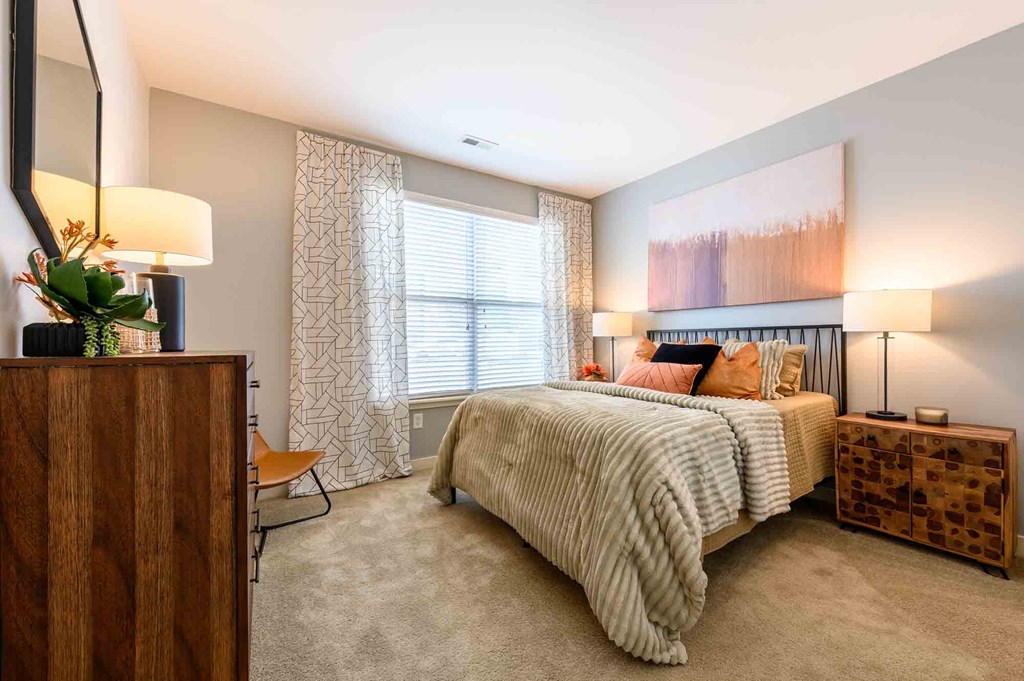 A bedroom with a large bed and a wooden dresser.