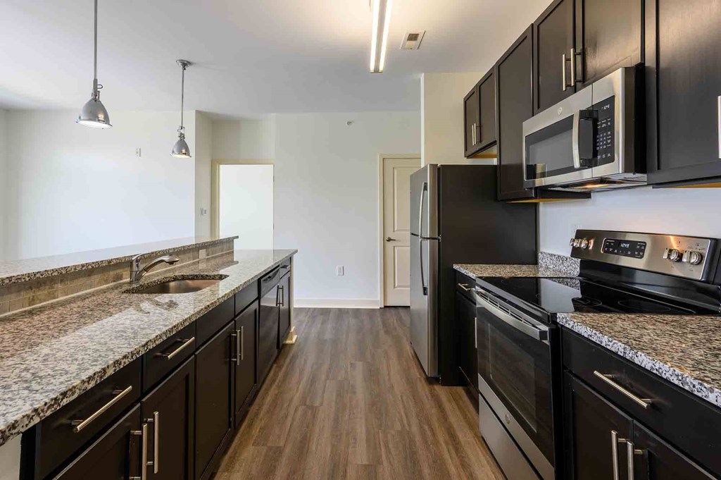 A kitchen with black cabinets and granite countertops.