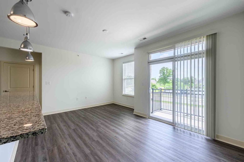 A spacious room with a marble countertop and sliding glass doors leading to a balcony.