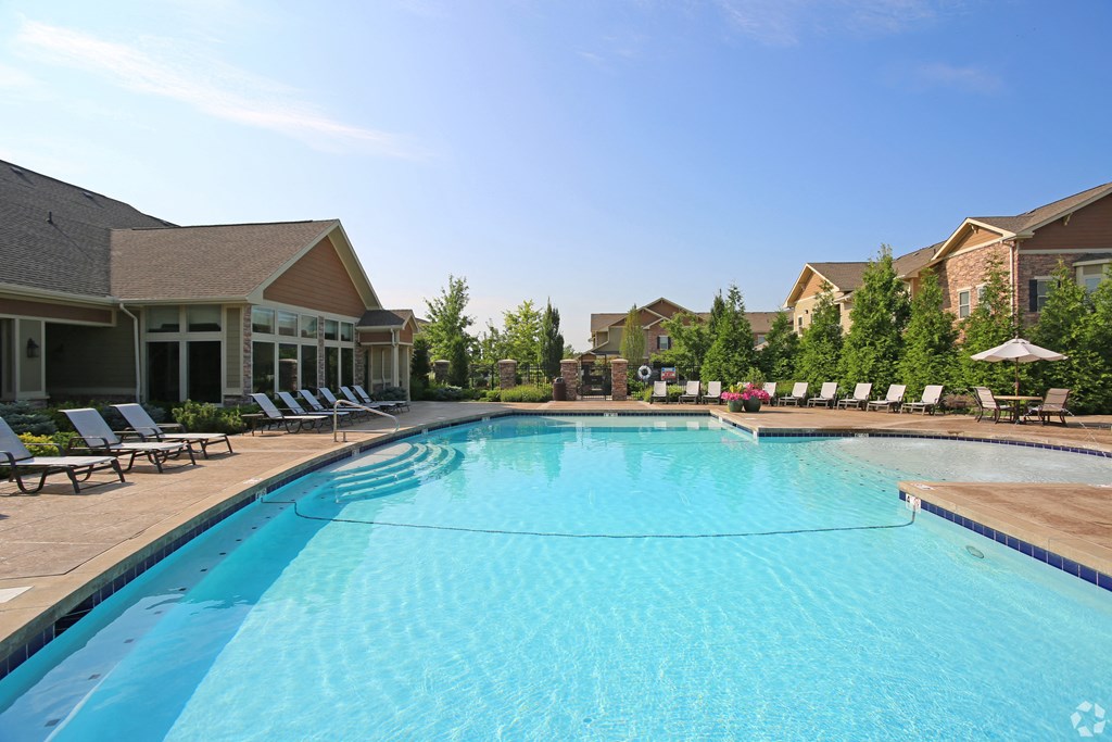 a swimming pool with lounge chairs and buildings in the background at Sovereign at Overland Park, Kansas, 66213