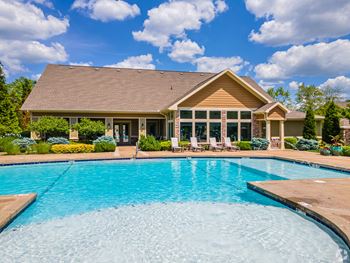 a swimming pool with a house in the background at Sovereign at Overland Park, Overland Park