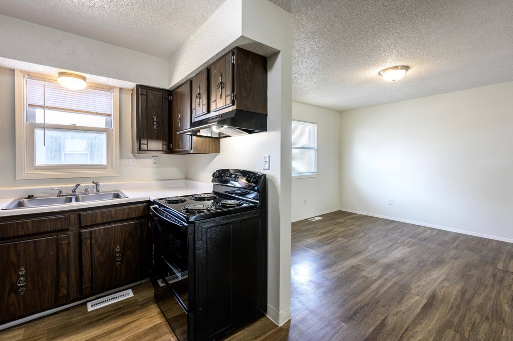 A kitchen with a black fridge and wooden cabinets at Spring Creek Townhomes Apartments, Springfield, IL 62702