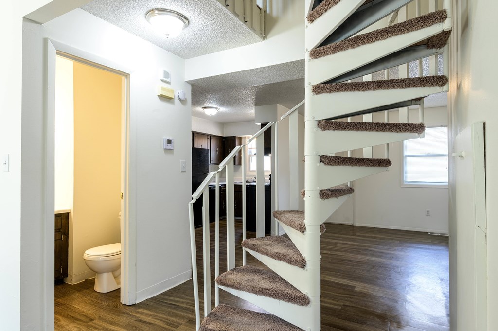 A white staircase with a carpeted runner leads to a second floor at Spring Creek Townhomes Apartments, Springfield, Illinois