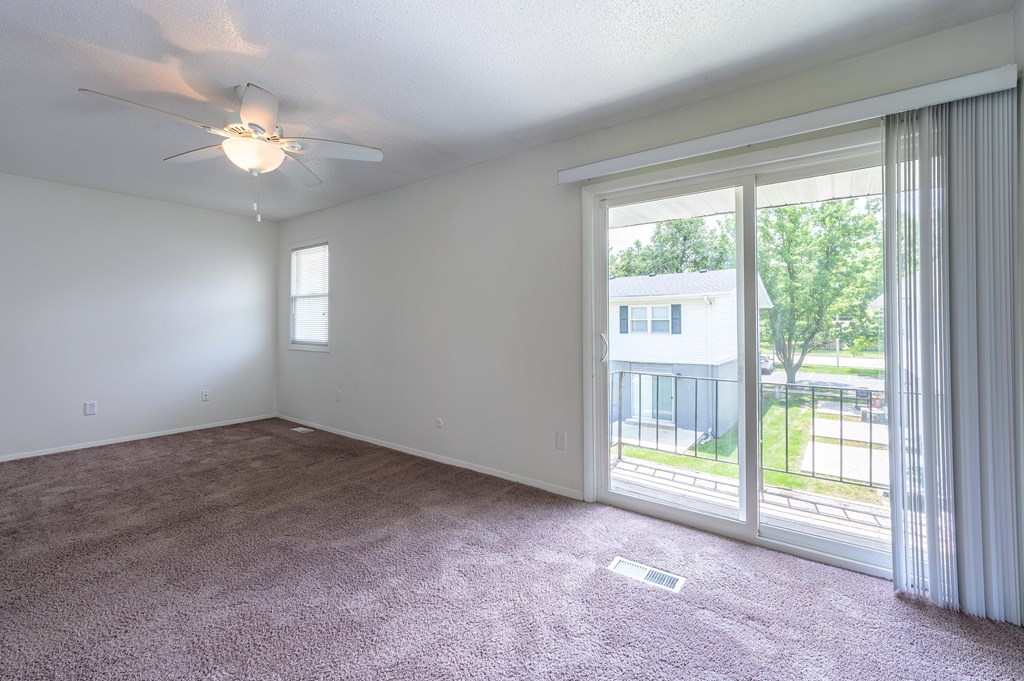 A room with a ceiling fan and sliding glass doors at Spring Creek Townhomes Apartments, Illinois 62702