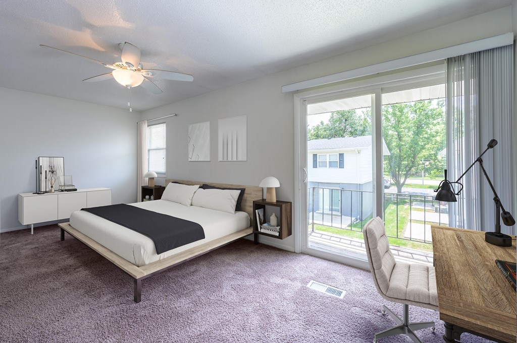 A bedroom with a large bed and a balcony view at Spring Creek Townhomes Apartments, Illinois 62702