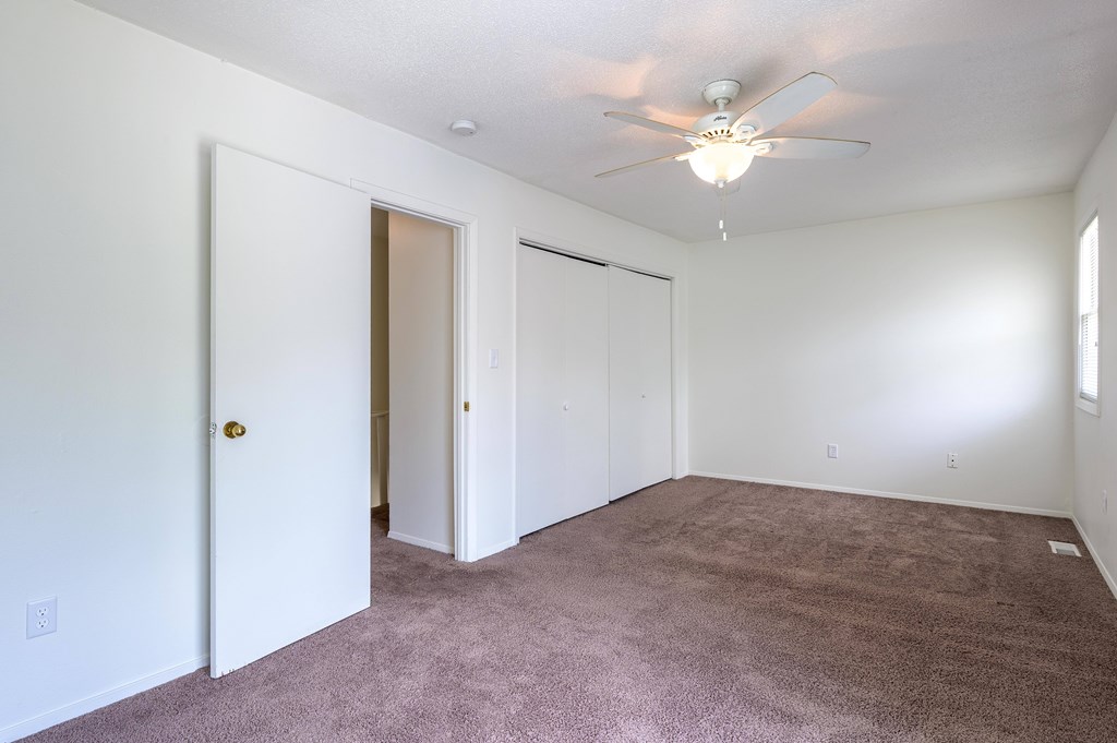 A room with a ceiling fan and carpeted floor at Spring Creek Townhomes Apartments, Illinois