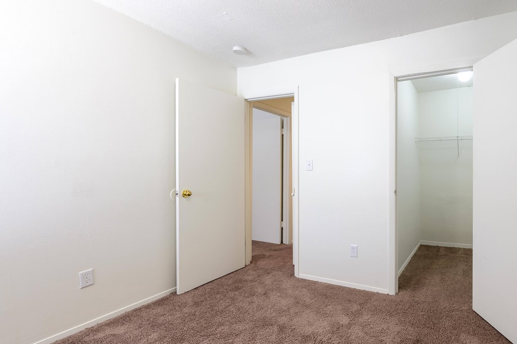A white door with a gold handle is in a room with carpeted flooring at Spring Creek Townhomes Apartments, Illinois 62702