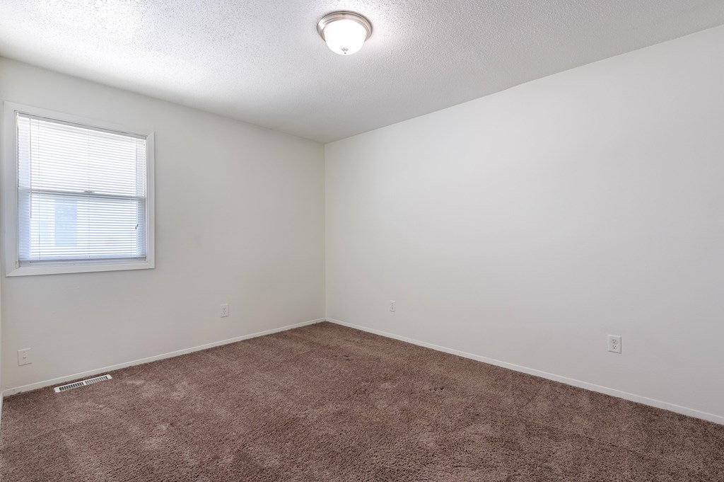 A room with a window and carpeted floor at Spring Creek Townhomes Apartments, Springfield, IL
