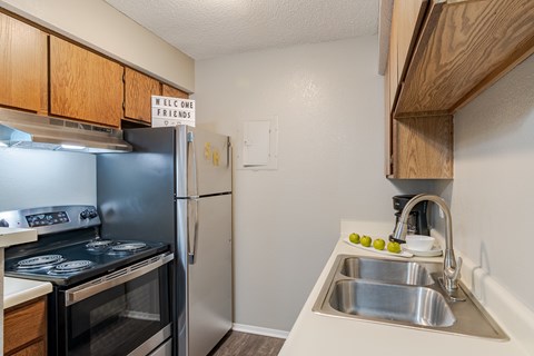 A kitchen with a refrigerator and a stove top oven.